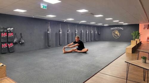 Deelnemer voert een oefening uit tijdens de mobiliteit en stabiliteitstraining voor betere heupflexibiliteit en balans.